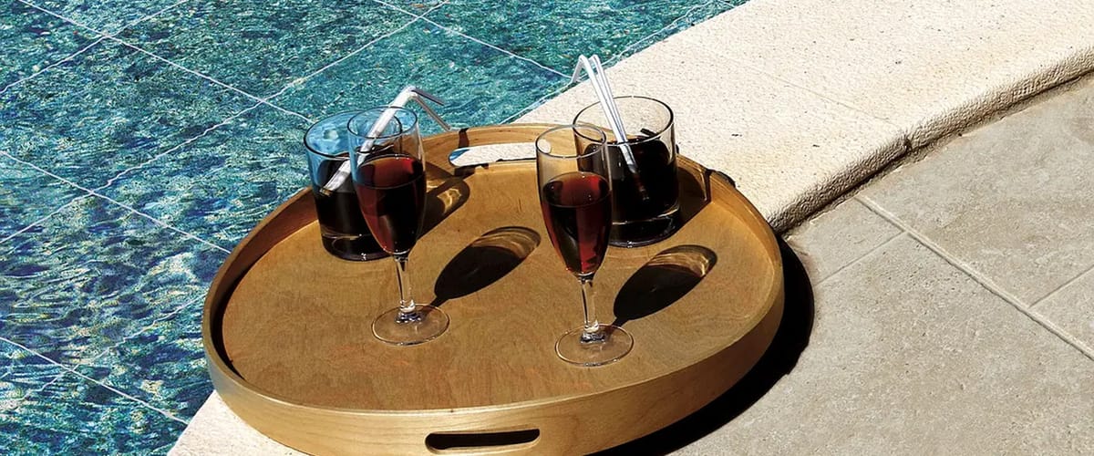 Carrelage terrasse effet travertin beige posé autour d'une piscine aux eaux bleues sur terrasse extérieure ensoleillée