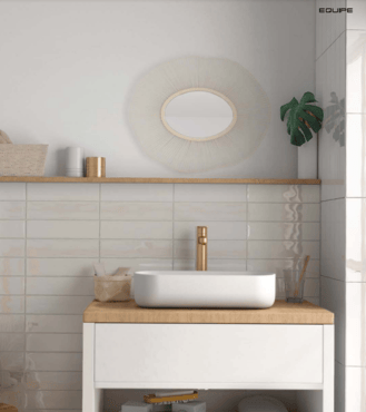 Zellige beige clair dans une salle de bain épurée aux murs blancs, avec vasque design, robinetterie dorée et miroir rond