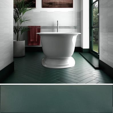 Carrelage uni vert sur une salle de bain épurée aux murs blancs avec baignoire blanche et serviettes rouges, plantes vertes et l