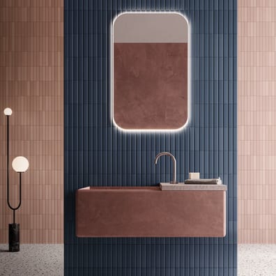 Carrelage uni rose dans une salle de bain aux murs bleu marine et rose pâle avec sol terrazzo et mobilier brun