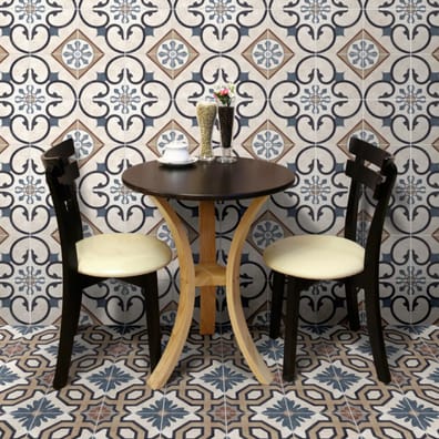 Carreau de ciment multicouleur motifs traditionnels 20x20 cm dans un café avec des murs et sol assortis, table en bois marron, c