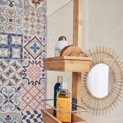 Carreau de ciment multicouleur motifs variés 30x30 cm dans une salle de bain beige avec bois, étagère et miroir soleil