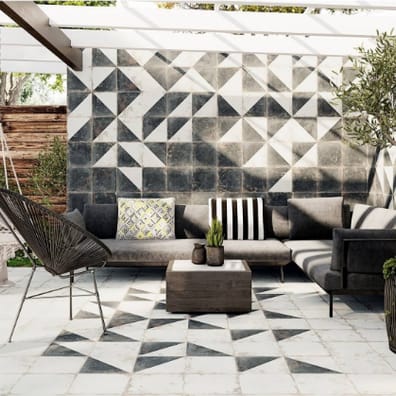 Carreau de ciment blanc avec motifs géométriques gris 30x30 cm dans une terrasse extérieure couleurs neutres avec mobilier dexté