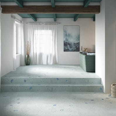 Carrelage pierre vert clair avec incrustations bleues 50x100 cm dans un salon aux murs blancs et canapé taupe, sous toit en bois