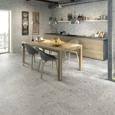 Carrelage effet pierre gris nuancé 80x80 cm dans une cuisine moderne blanc et bois avec table, chaises et éléments décoratifs