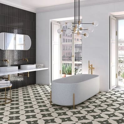 Carrelage Terrazzo noir et blanc dans une salle de bain élégante avec baignoire ovale et robinetterie dorée sur fond de murs gri