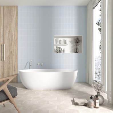 Carrelage unis bleu clair dans une salle de bain épurée avec baignoire blanche, revêtements bois et touches de gris, éclairée pa