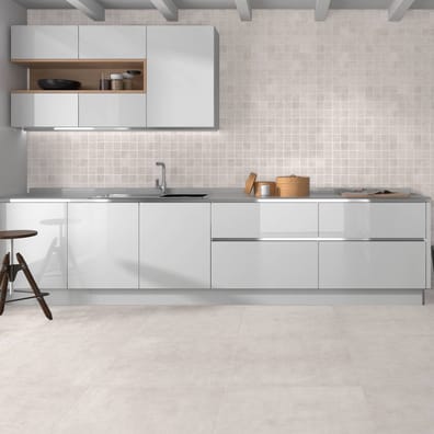 Carrelage effet béton blanc sans motifs dans une cuisine moderne aux meubles blancs et plan en bois clair, avec tabouret haut