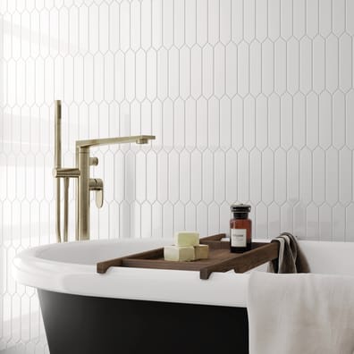 Carrelage uni blanc dans une salle de bain épurée avec baignoire noire et blanche, accents dorés, serviettes et accessoires rela