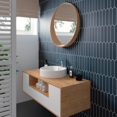 Carrelage uni bleu foncé 5X25 dans salle de bain moderne sur meuble en bois clair, blanc, avec miroir rond et lavabo blanc, plan