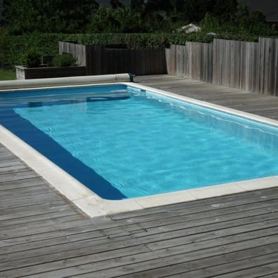 Carreau de ciment bleu clair et foncé sur une terrasse en bois autour dune piscine extérieure aux tons bleu ciel