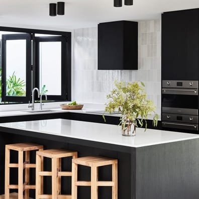 Carrelage Zellige Blanc brillant taille 6,5X20 sur un mur de cuisine moderne avec meubles noirs, plans de travail en quartz, tab