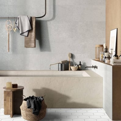Carrelage effet pierre blanc léger, hexagonal 17.5x20 cm, sur un sol de salle de bain, harmonie avec les murs beiges, accessoire