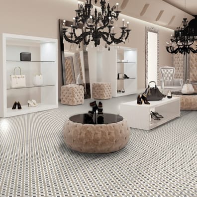 Carreau de ciment or avec motifs géométriques 20x20 cm dans boutique mode chic avec habillage blanc et lustres noirs