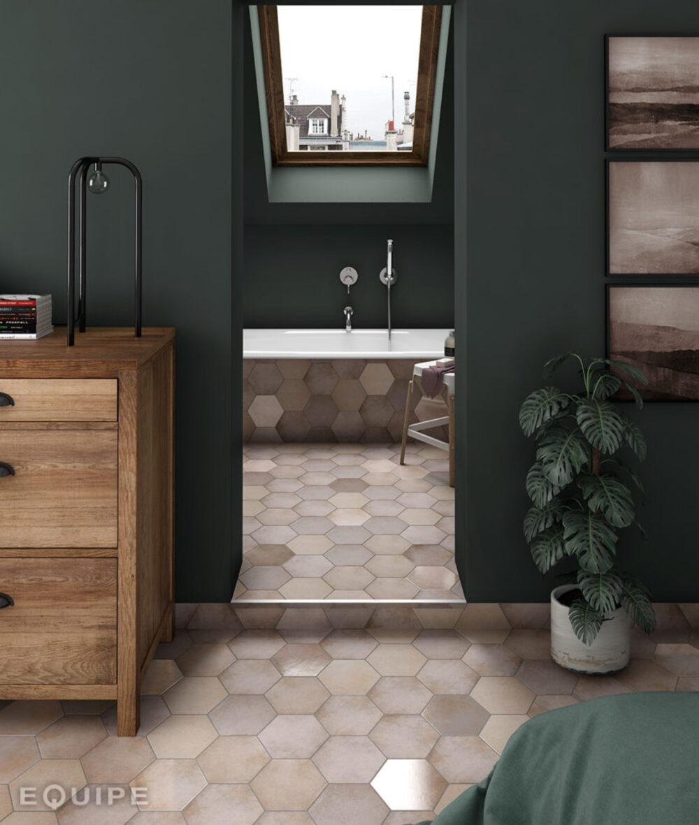 Carrelage brique rose hexagonal dans une salle de bain aux murs verts, avec meubles en bois et plantes vertes