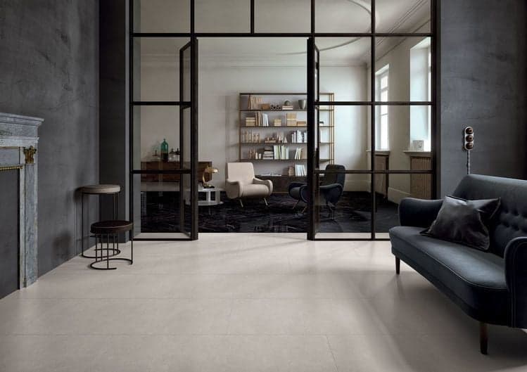 Carrelage lisse gris clair 60x60 cm dans un salon moderne aux murs gris et mobilier noir et bois