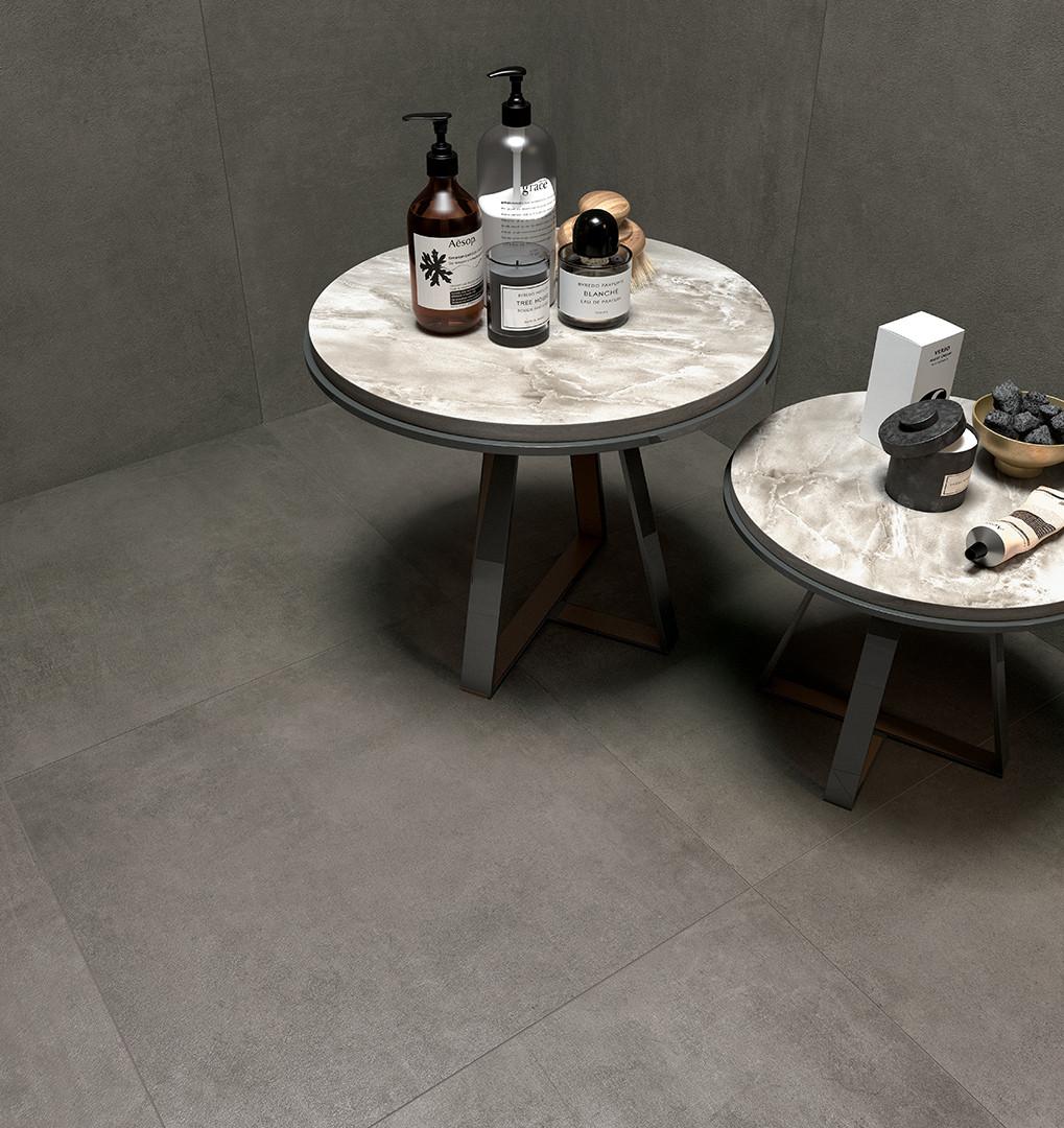 Carrelage effet pierre gris nuances douces 80x80 cm dans une pièce sobre produits de bain sur table en marbre