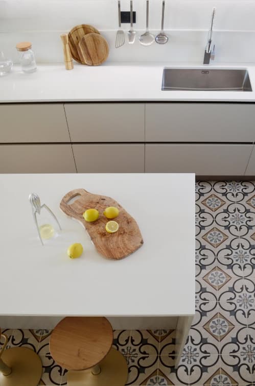 Carreau de ciment multicolore motifs floraux 20x20 cm dans une cuisine blanche avec mobilier moderne et accessoires en bois