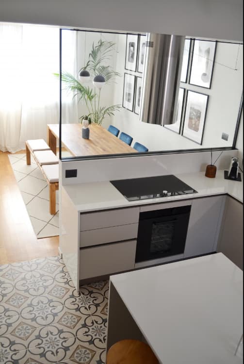 Carreau de ciment multicouleur avec motifs 20x20 cm dans une cuisine blanche avec meubles modernes et détails en bois