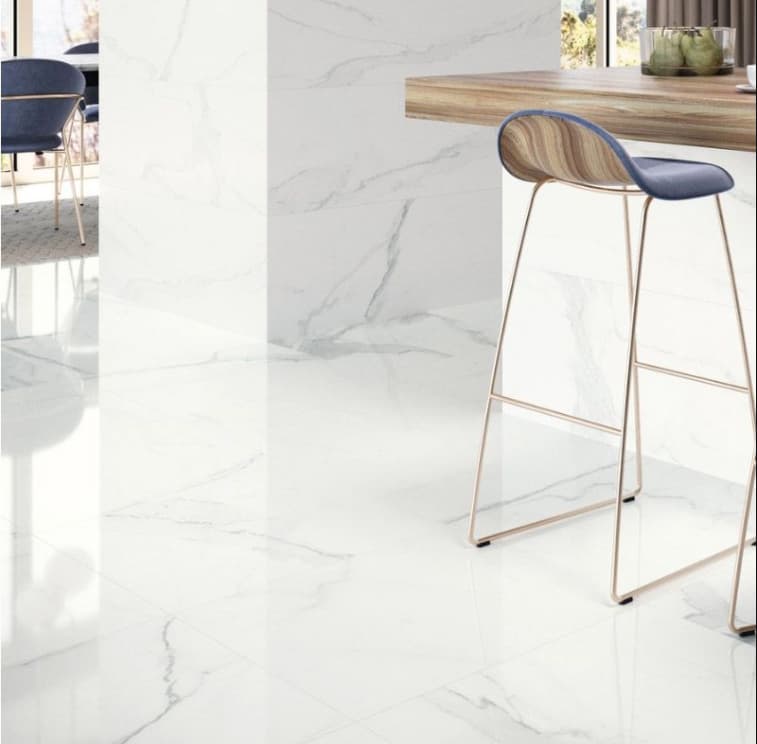 Carrelage marbre blanc veiné 60x120 cm dans une salle à manger moderne avec chaise bleue, plan de travail en bois