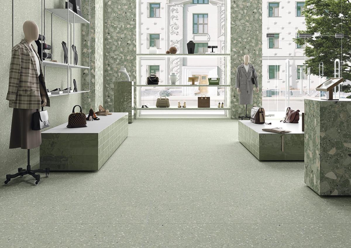Carrelage Terrazzo vert avec nuances dans boutique moderne sur murs et sol 80x80 cm éclairée mobilier blanc et mannequins
