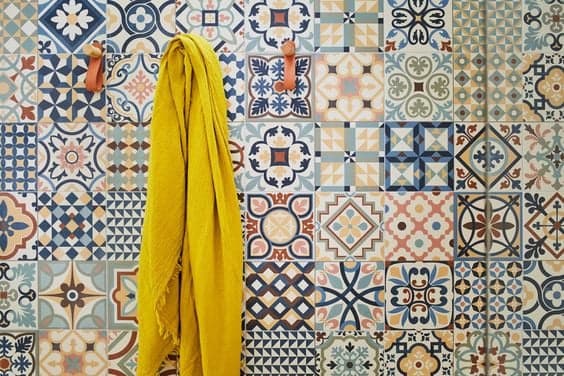 Carreau de ciment multicouleur motifs géométriques et floraux 30x30 cm sur une salle de bain murs blancs serviette jaune suspendue