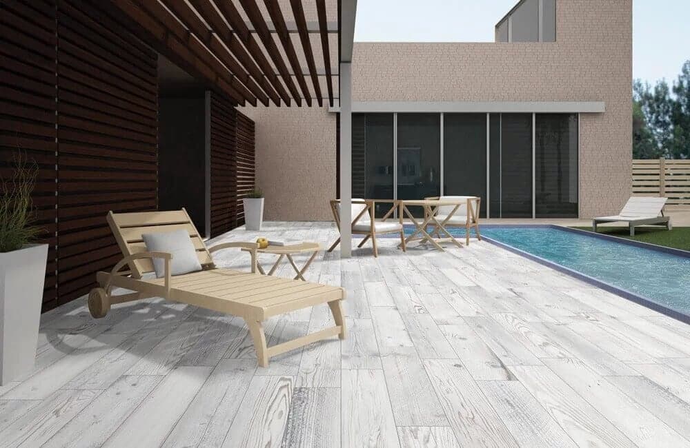 Carrelage effet bois marron clair nuances de gris sans motifs 15x90 cm sur terrasse piscine bleue chaises longues beige