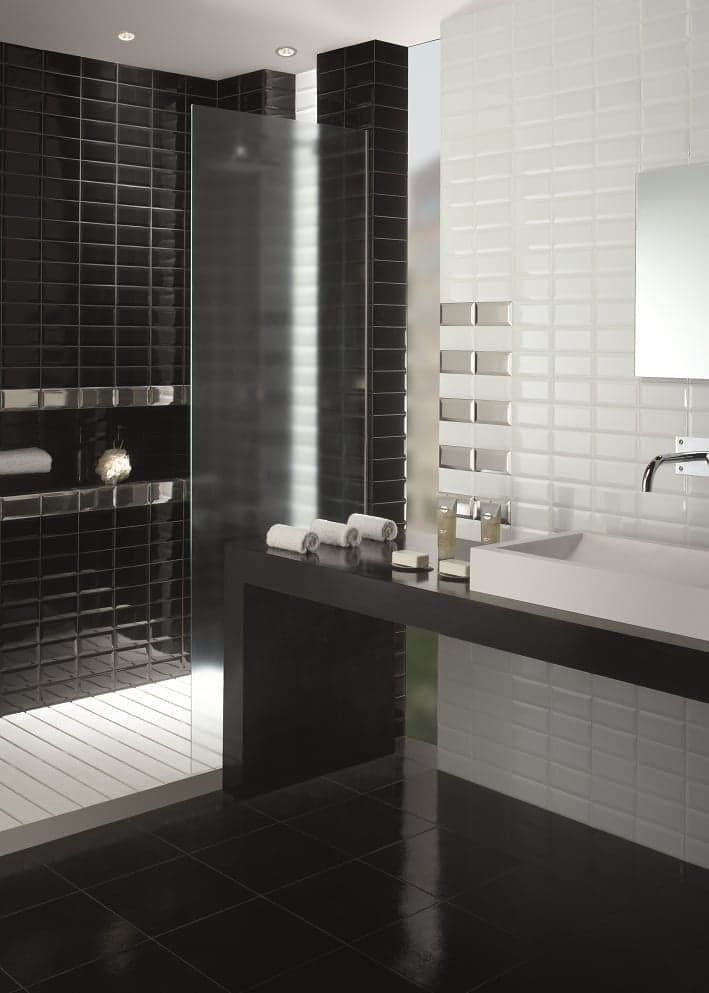Carrelage uni blanc dans une salle de bain moderne avec murs noirs et blancs, vasque blanche, miroir et éclairage encastré
