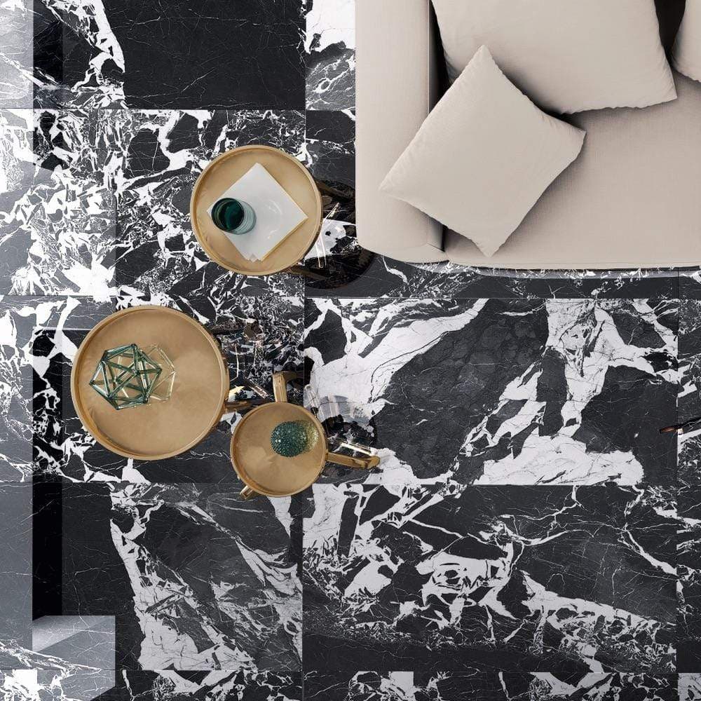 Carrelage effet marbre noir nuances de gris 60x120 cm sur un sol avec table basse éléments dorés et accessoires verts