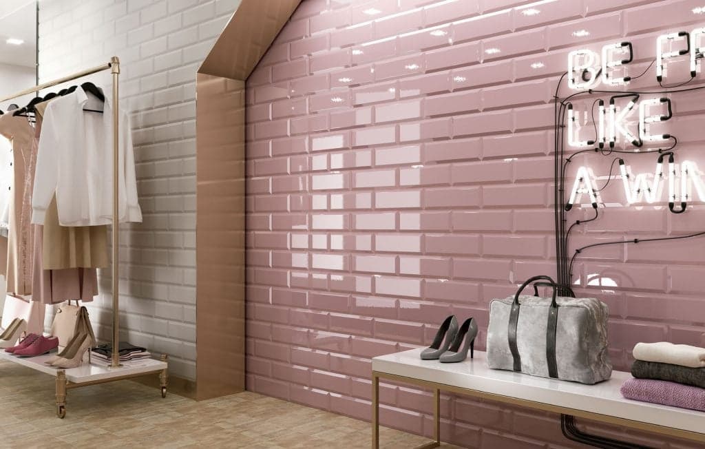 Carrelage uni beige 10x30 cm dans un magasin de vêtements éclairé, agencé avec des accessoires de mode et une déco néon