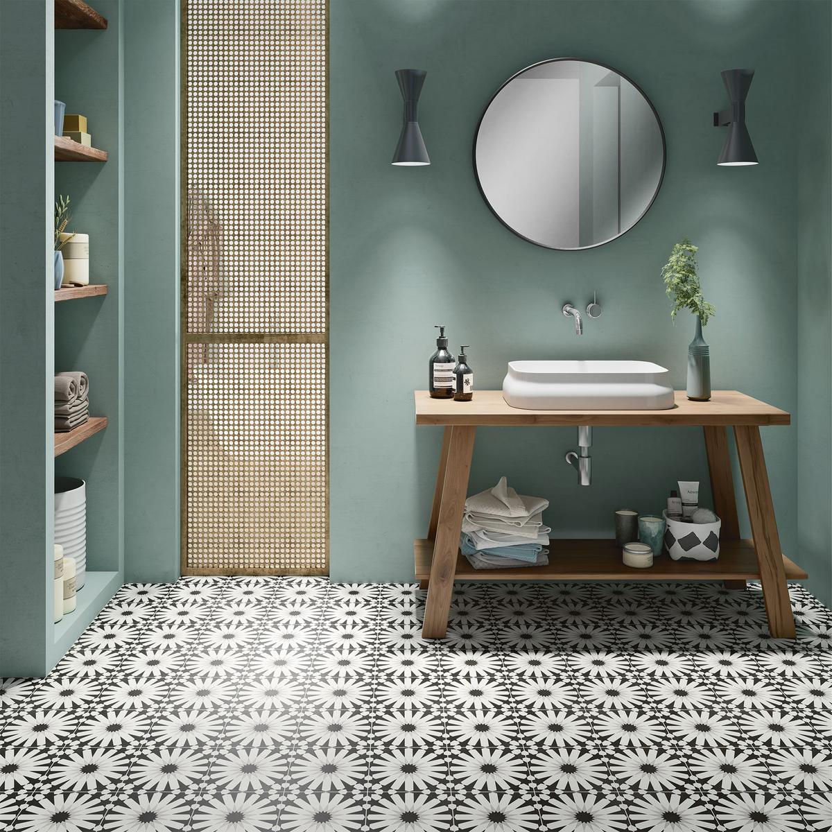 Carreau de ciment noir et blanc à motifs 20x20 cm dans une salle de bain vert deau avec lavabo, miroir et accessoires en bois
