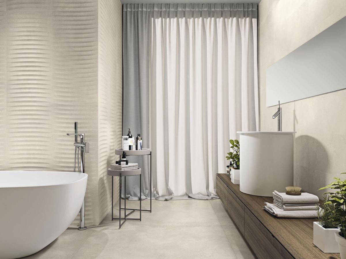 Carrelage aspect béton beige lisse 80x80 cm dans une salle de bain moderne tons blancs meubles bois plantes vertes et baignoire blanche
