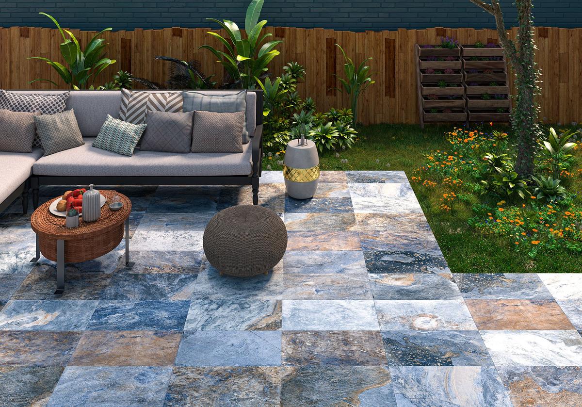 Carrelage effet pierre multicouleur nuances bleu-gris-beige 30x60 cm dans jardin extérieur tons verts mobilier de détente beige et bois éléments de déco
