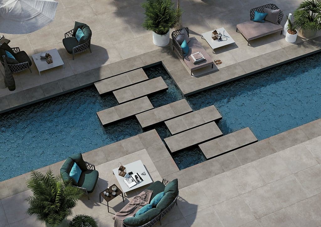Carrelage aspect pierre gris uni en 60x60 cm dans un espace extérieur avec piscine, mobilier moderne et plantes vertes