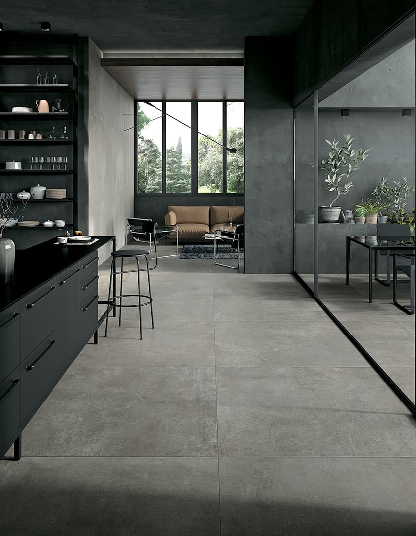Carrelage effet pierre gris nuances subtiles 60x60 cm dans une cuisine moderne tonalités sombres meubles noir et éléments décoratifs verts
