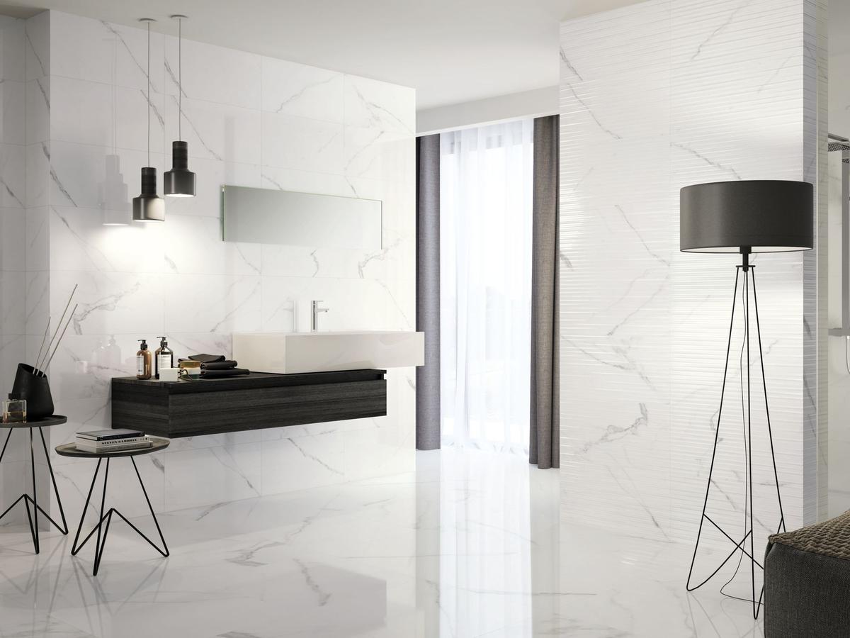 Carrelage blanc effet marbre dans salle de bain moderne aux murs et sols blancs avec meuble vasque noir et lampadaire élégant