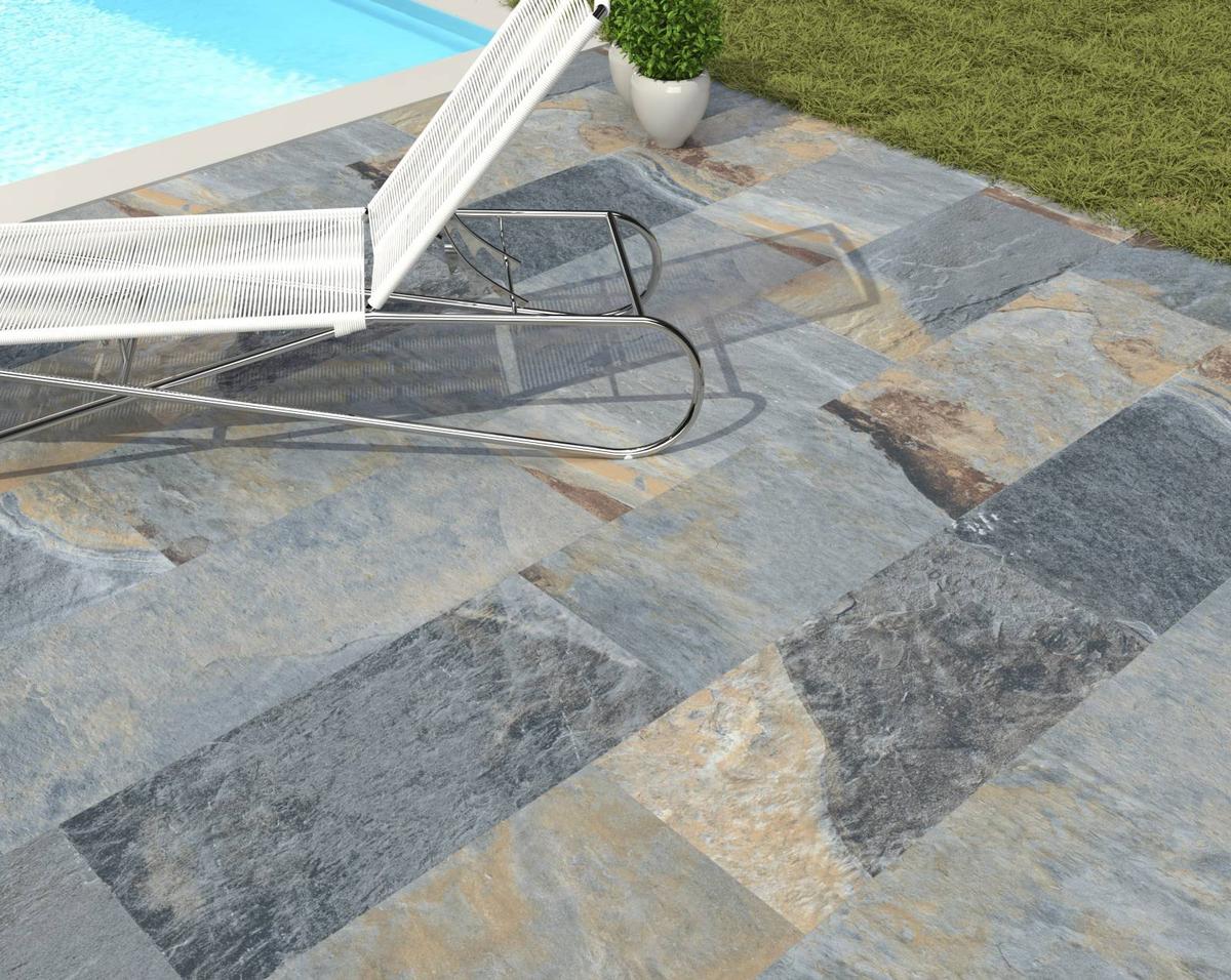 Carrelage effet pierre multicolore nuances de gris et beige 30x60 cm en extérieur bord de piscine avec chaise longue blanche et pot de plante