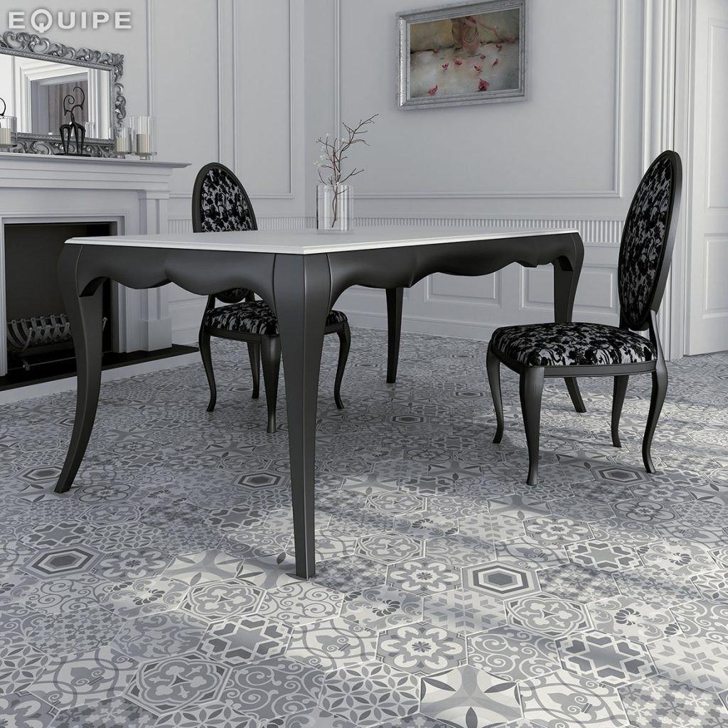 Carreau de ciment noir et gris motifs géométriques et floraux 17.5x20 cm dans une salle à manger blanche aux murs texturés avec table et chaises élégantes