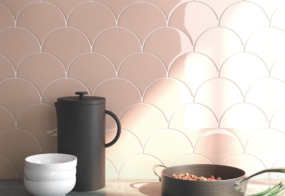 Carrelage uni rose poudré en écailles taille 13,4X15 sur une cuisine moderne avec vaisselle et ustensiles gris foncé et plan de travail en marbre