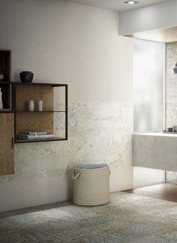 Carrelage aspect tissu beige avec motifs dans une salle de bain tons crème et bois avec étagère, panier et serviettes