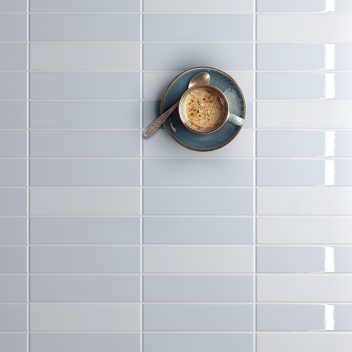Carrelage uni bleu clair émaillé avec tasse de café posée dessus dans cuisine moderne avec des éléments blancs