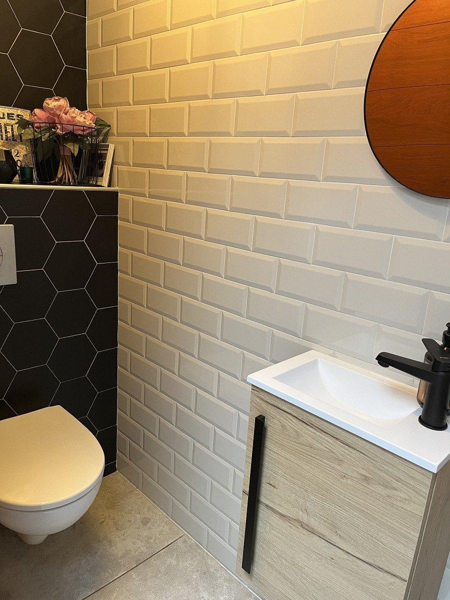 Carrelage uni blanc 10x20 cm dans une salle de bains moderne avec meuble bois et carrelage noir hexagonal