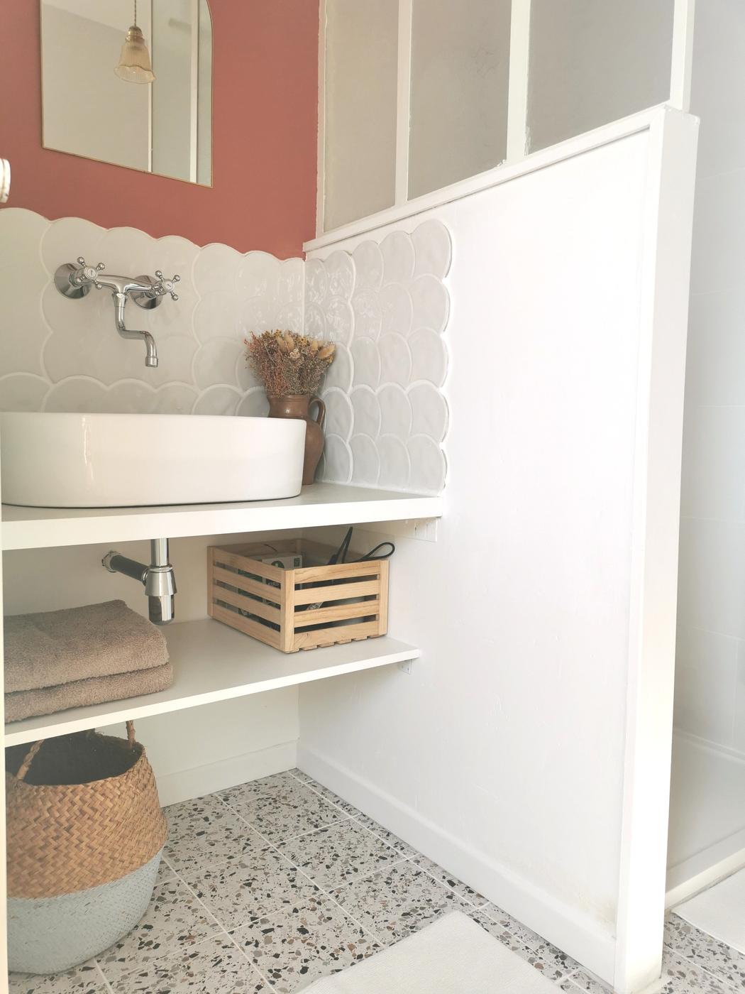 Carrelage uni blanc sans motifs 30x30 cm dans une salle de bain aux murs terracotta avec vasque et accessoires en bois