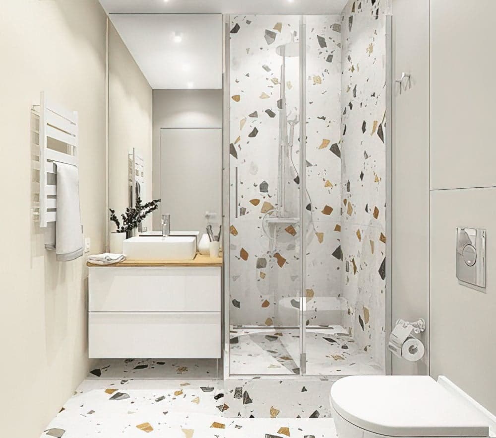 Carrelage Terrazzo blanc avec éclats colorés 60x60 cm dans une salle de bain beige avec mobilier blanc et miroir
