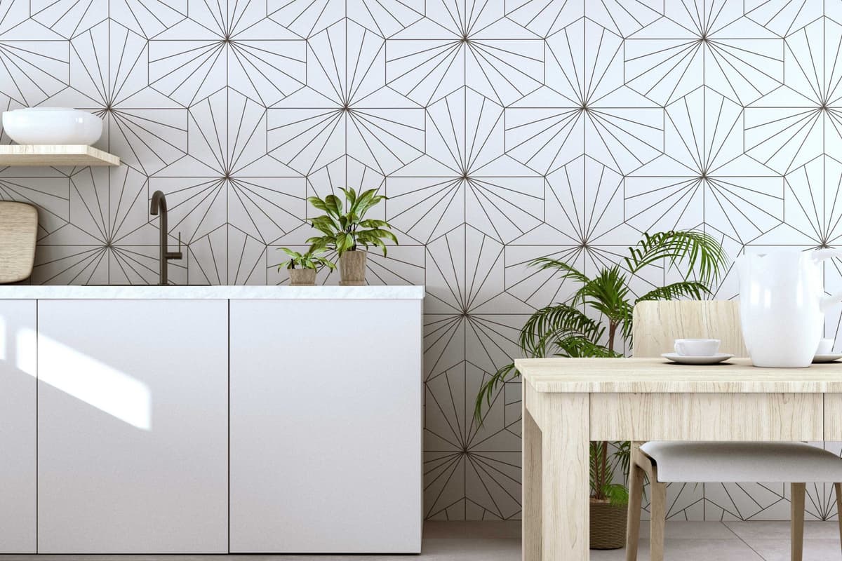 Carreau de ciment blanc avec motifs géométriques sur une cuisine moderne tons bois et blanche avec vaisselle et plantes