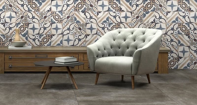 Carreau de ciment multicouleur avec motifs géométriques et étoiles 20x20 cm dans un salon aux tons beige fauteuil gris et meuble en bois