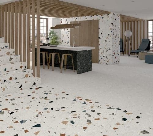 Carrelage Terrazzo blanc avec éclats multicolores 80x80 cm dans une cuisine moderne aux meubles en bois et noir, sol et murs clairs