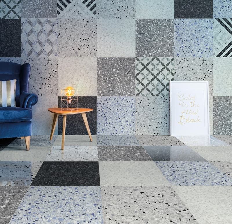 Carrelage Terrazzo Blanc nuances de gris et bleu 60x60 cm dans un salon fauteuil bleu table en bois affiche décorative