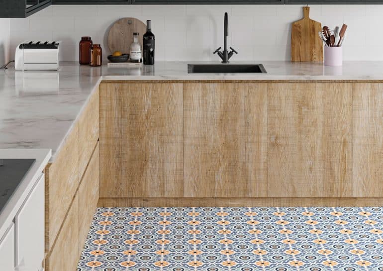 Carreau de ciment multicouleur avec motifs géométriques 30x30 cm dans une cuisine moderne blanche avec meubles en bois et plan de travail marbre