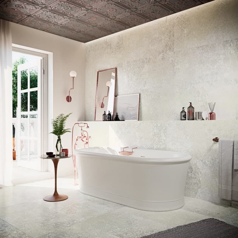 Carrelage uni beige 60x60 cm dans une salle de bain épurée blanc et touches de cuivre avec baignoire, miroirs, plante
